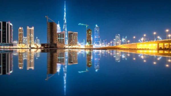 Fascinating reflection of tallest skyscrapers in Business Bay district during calm night. Dubai, United Arab Emirates.